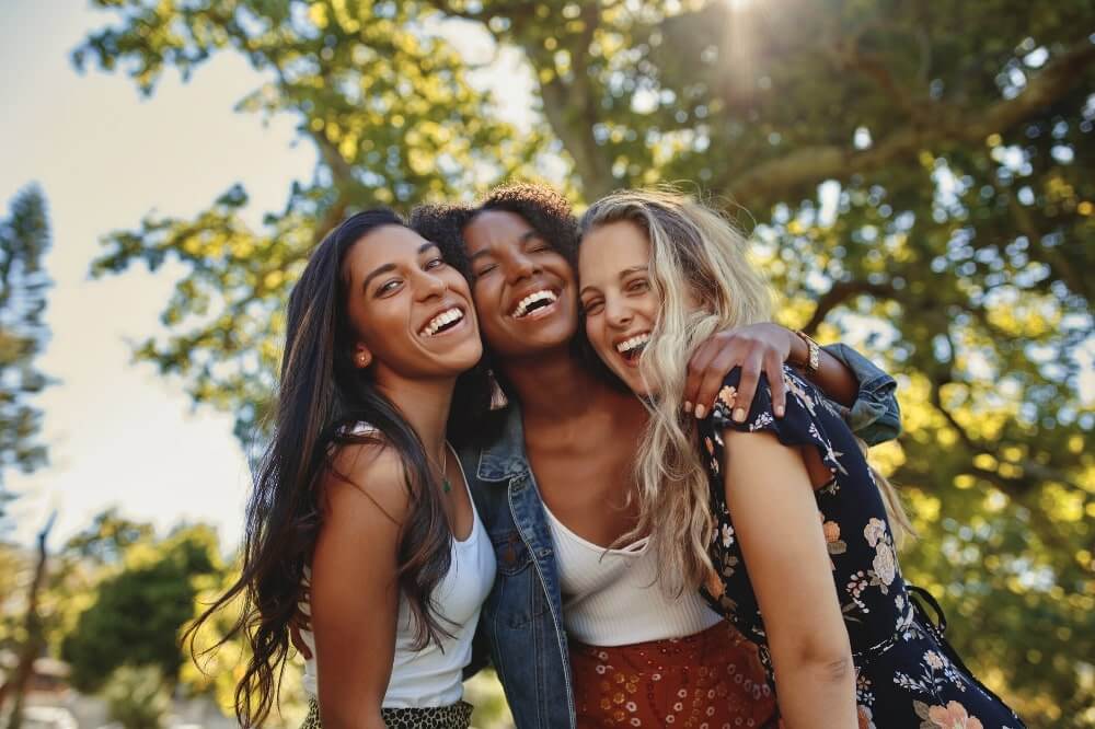 group of women with arms around each others shoulders smiling