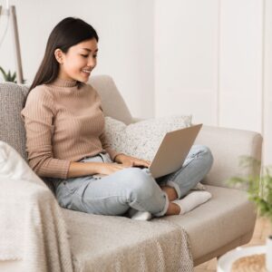 woman on loveseat with laptop