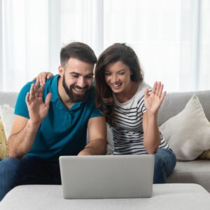 man and woman on a video call waving hello
