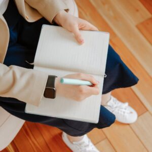 Person writing something in a notebook. 