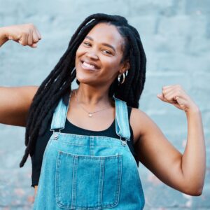 Woman flexing her biceps, smiling. 