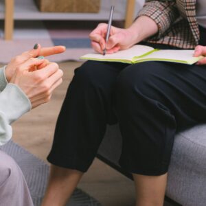 Therapist talking to a patient and taking notes. 