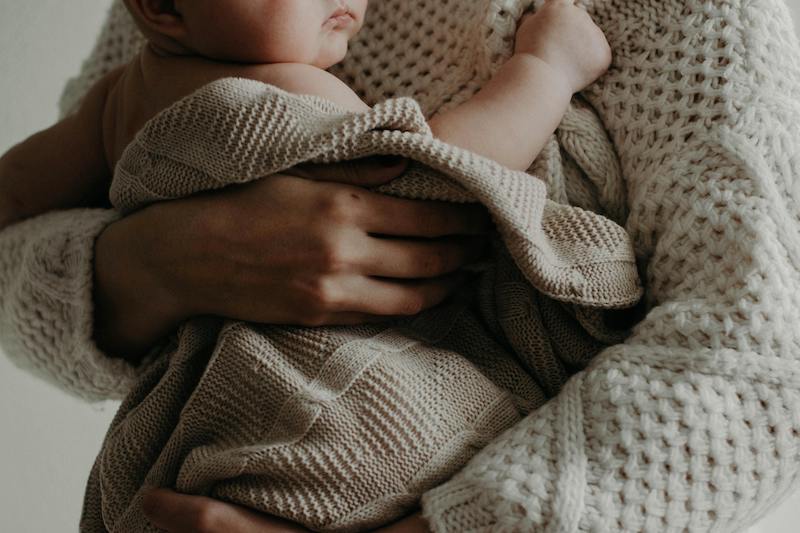 mother holding baby in blanket