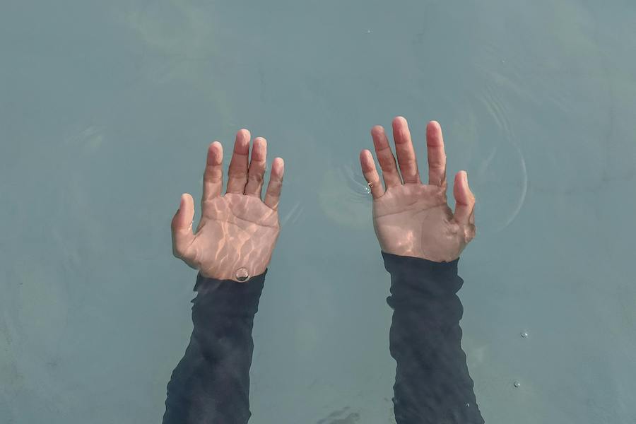 hands outstretched under water