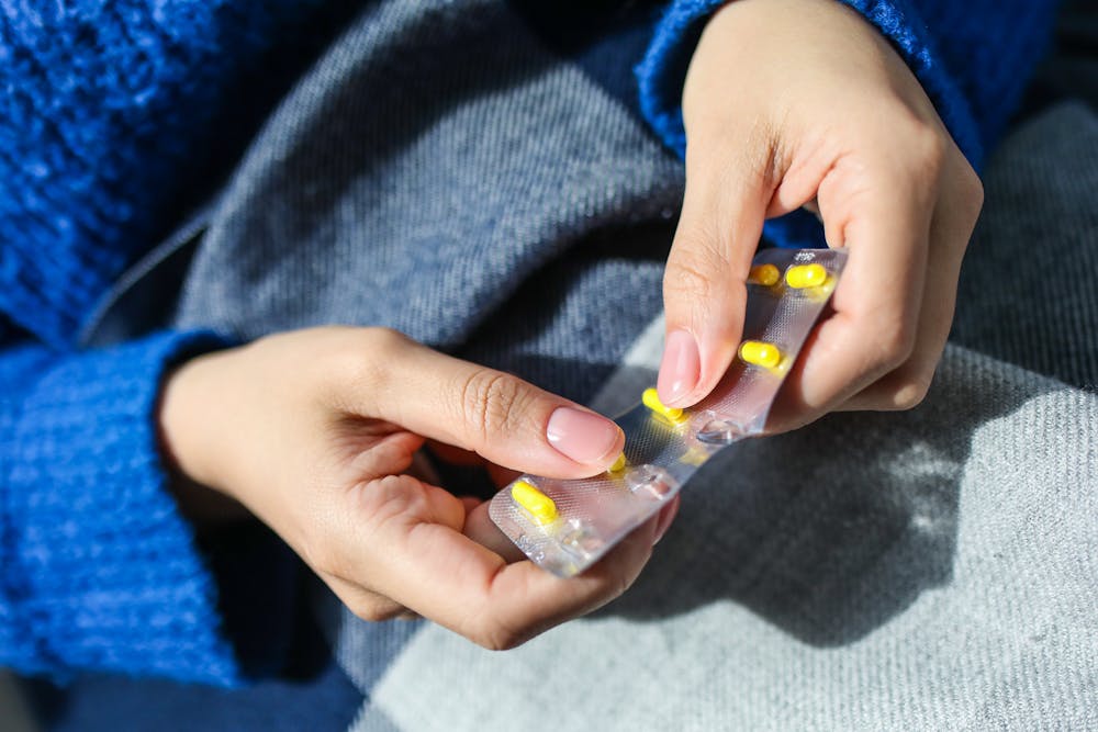 close up of person's hands opening up pill packaging