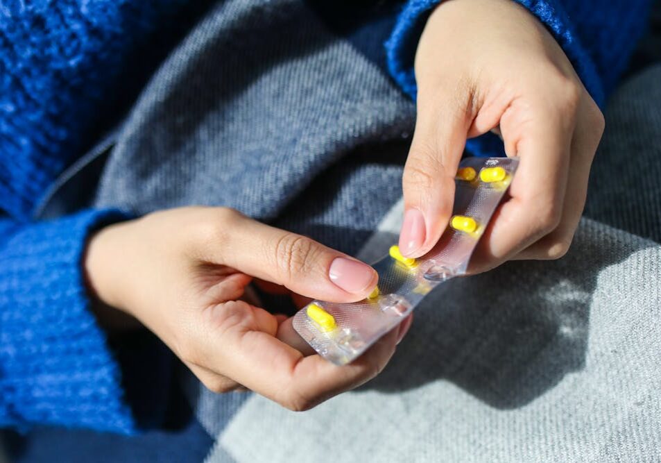 close up of person's hands opening up pill packaging