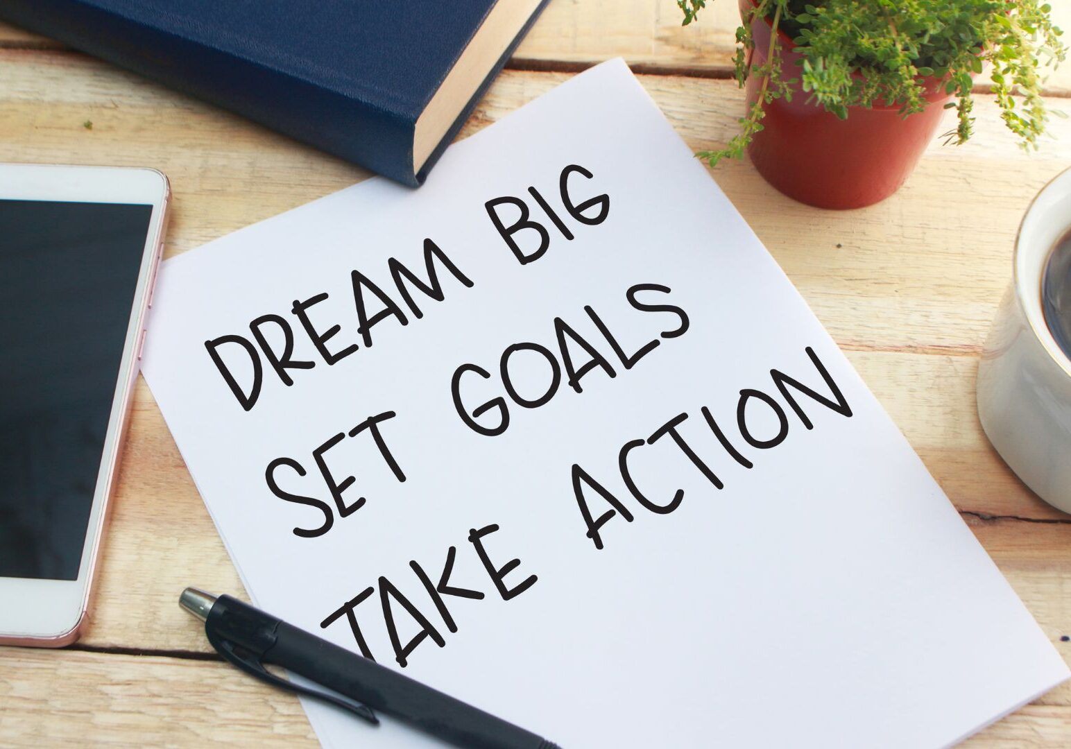Piece of paper that says "Dream Big, Set Goals, Take Action."