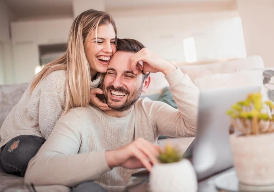 Couple laughing together on sofa