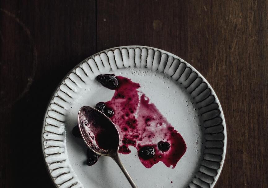 empty plate and spoon with fruit jam