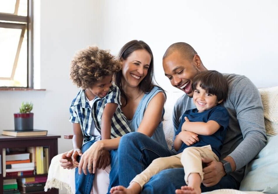 family sitting on sofa smiling together
