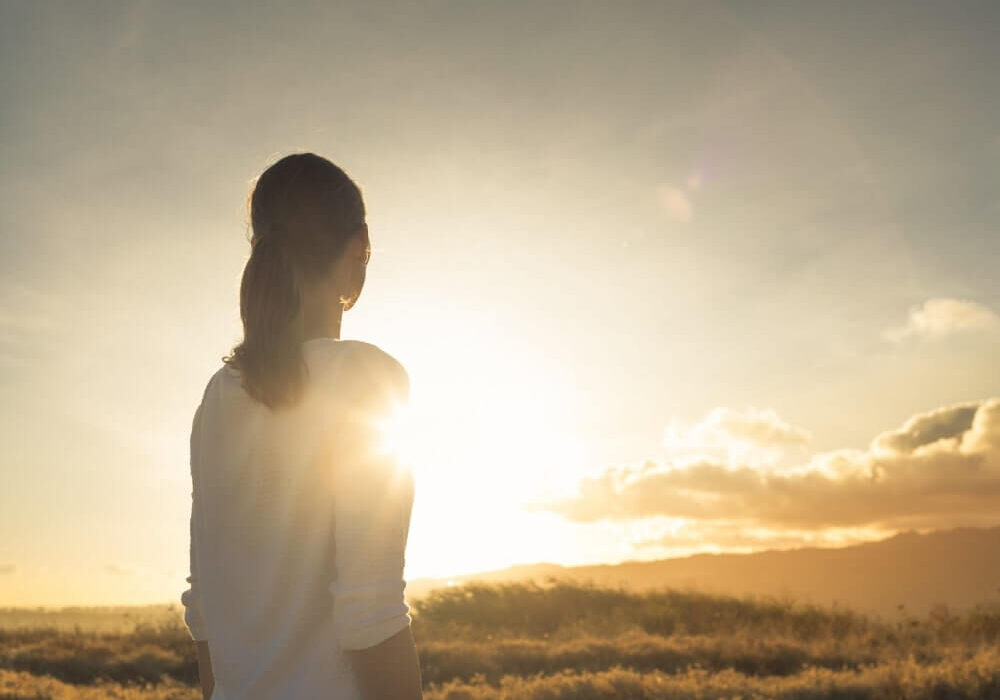 woman looking out to sunrise