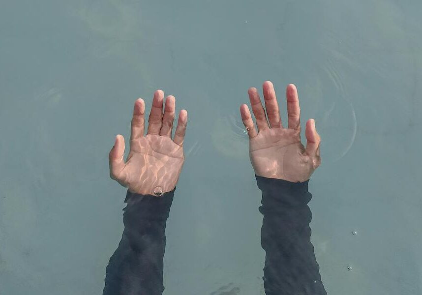 hands outstretched under water