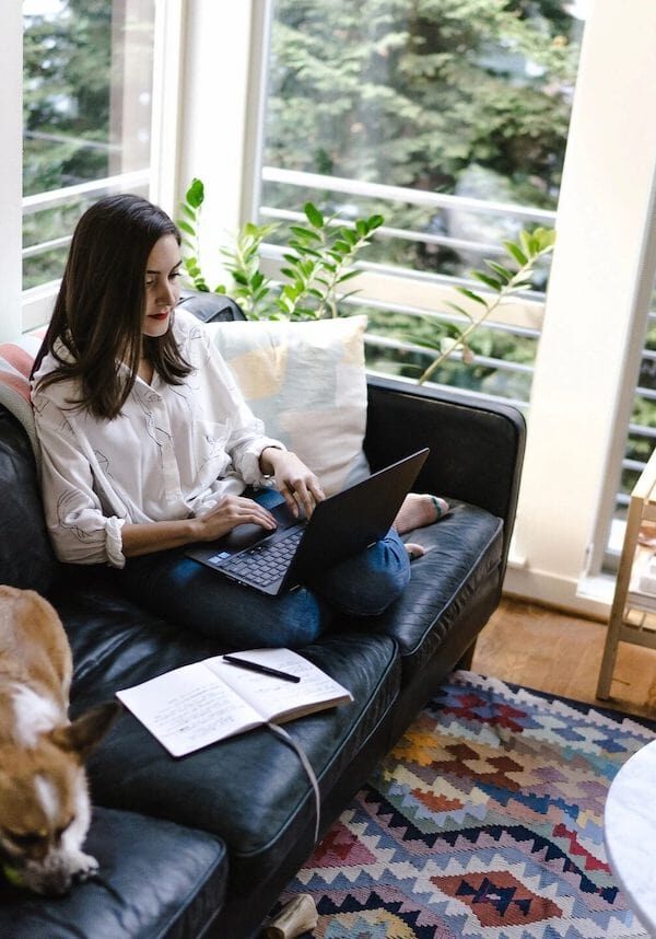 woman in bright living room using laptop
