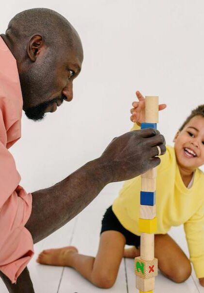 man building block tower with child