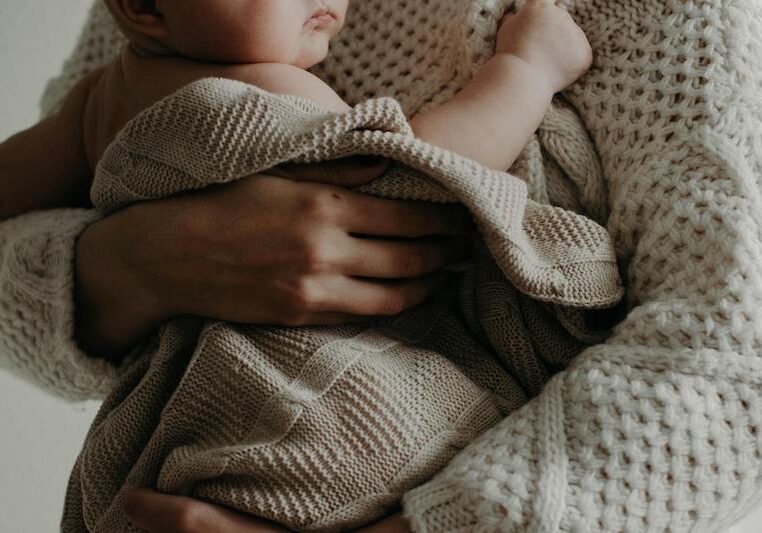 mother holding baby in blanket