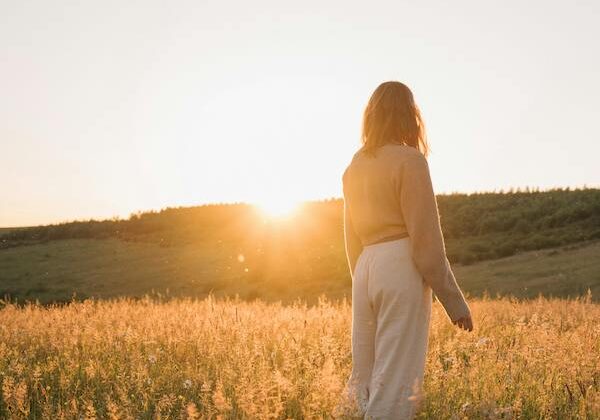 woman standing in field of flowers
