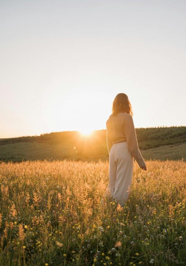 woman standing in field of flowers